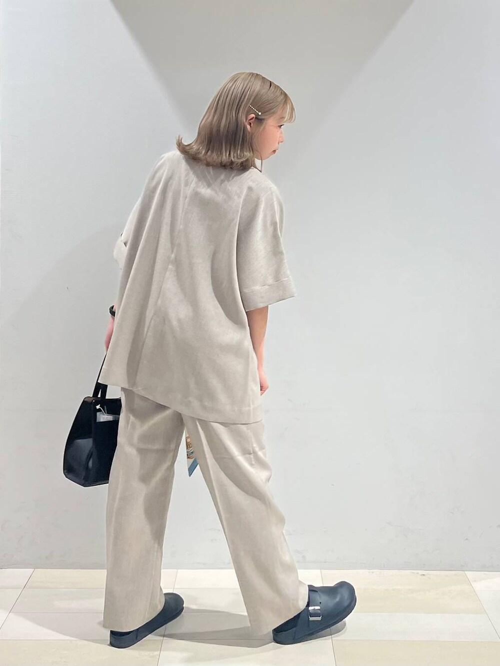 ブラック系のショルダーバッグ、ホワイト系のキャミソール、ブラック系のサンダルを着用したレディースの夏コーディネートの5枚目の写真