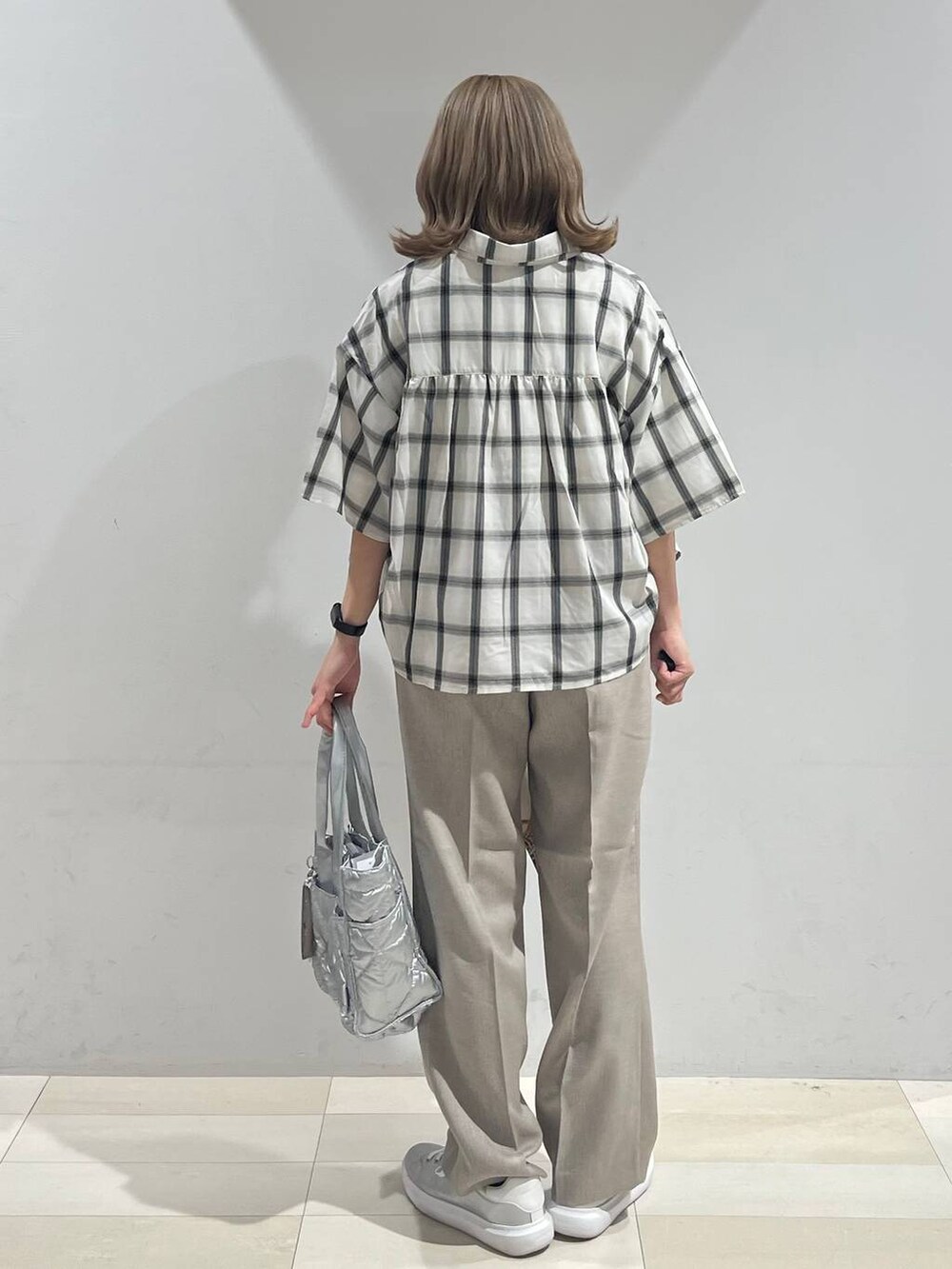 シルバー系のスニーカー、シルバー系のトートバッグ、ベージュ系のその他パンツを着用したレディースの夏コーディネートの3枚目の写真