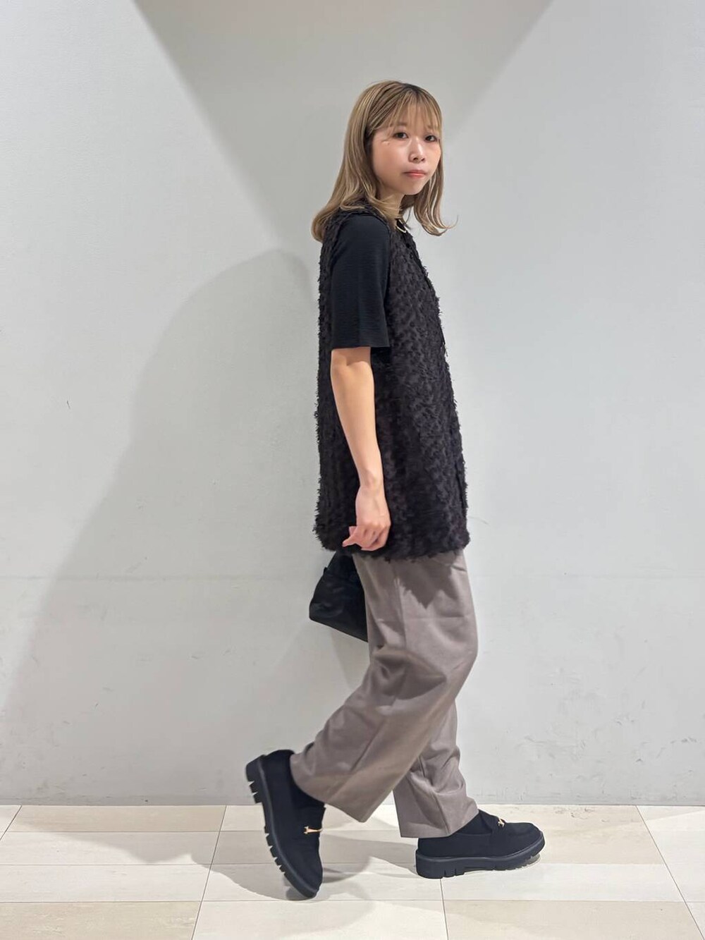 ブラック系のショルダーバッグ、ブラック系のTシャツ/カットソー、ブラック系のローファーを着用したレディースの秋コーディネートの3枚目の写真