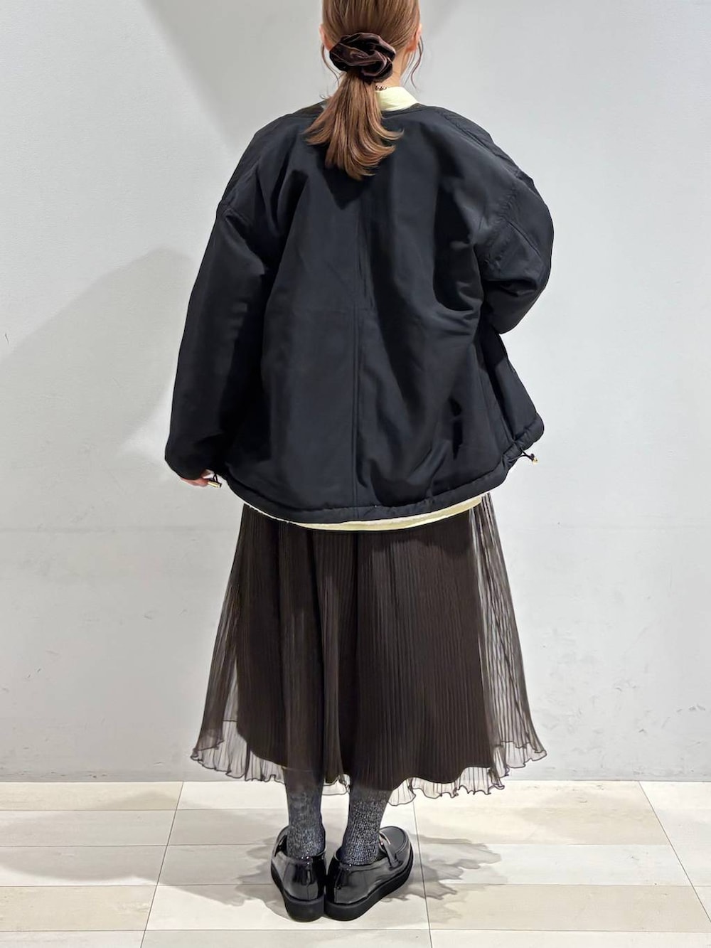 ブラック系のローファー、ブラック系のトートバッグ、ホワイト系のブルゾンを着用したレディースの秋コーディネートの8枚目の写真