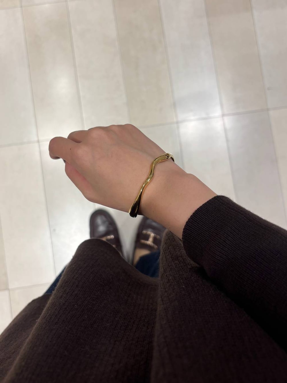 ブラウン系のローファー、ブルー系のデニムパンツ、ブラウン系のカーディガン/ボレロを着用したレディースの秋コーディネートの6枚目の写真