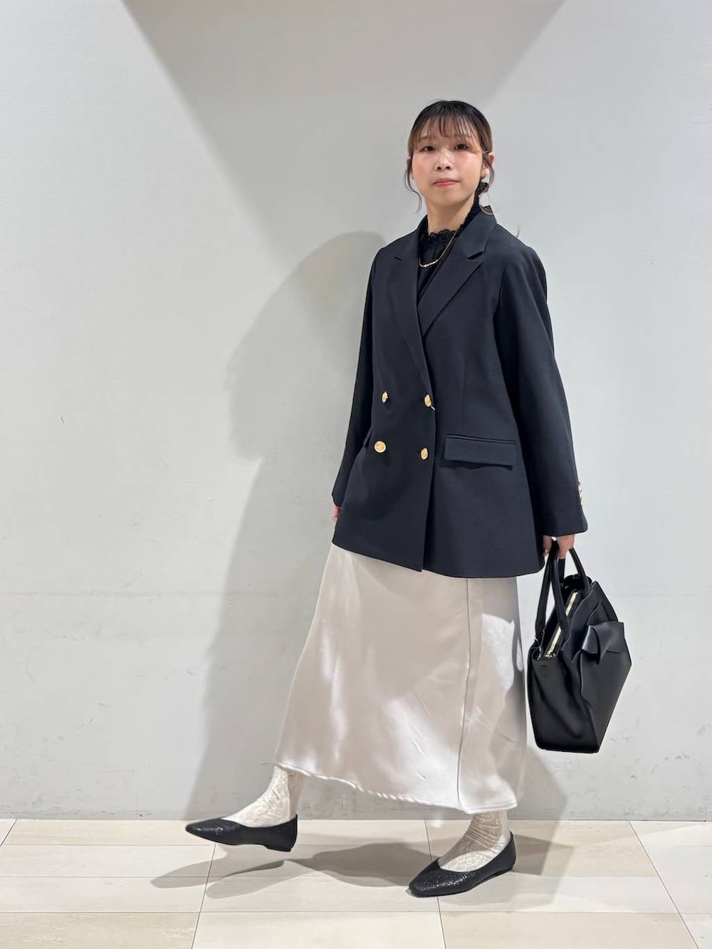 ブラック系のパンプス、ブラック系のシャツ/ブラウス、ブラック系のハンドバッグを着用したレディースの冬コーディネートの3枚目の写真