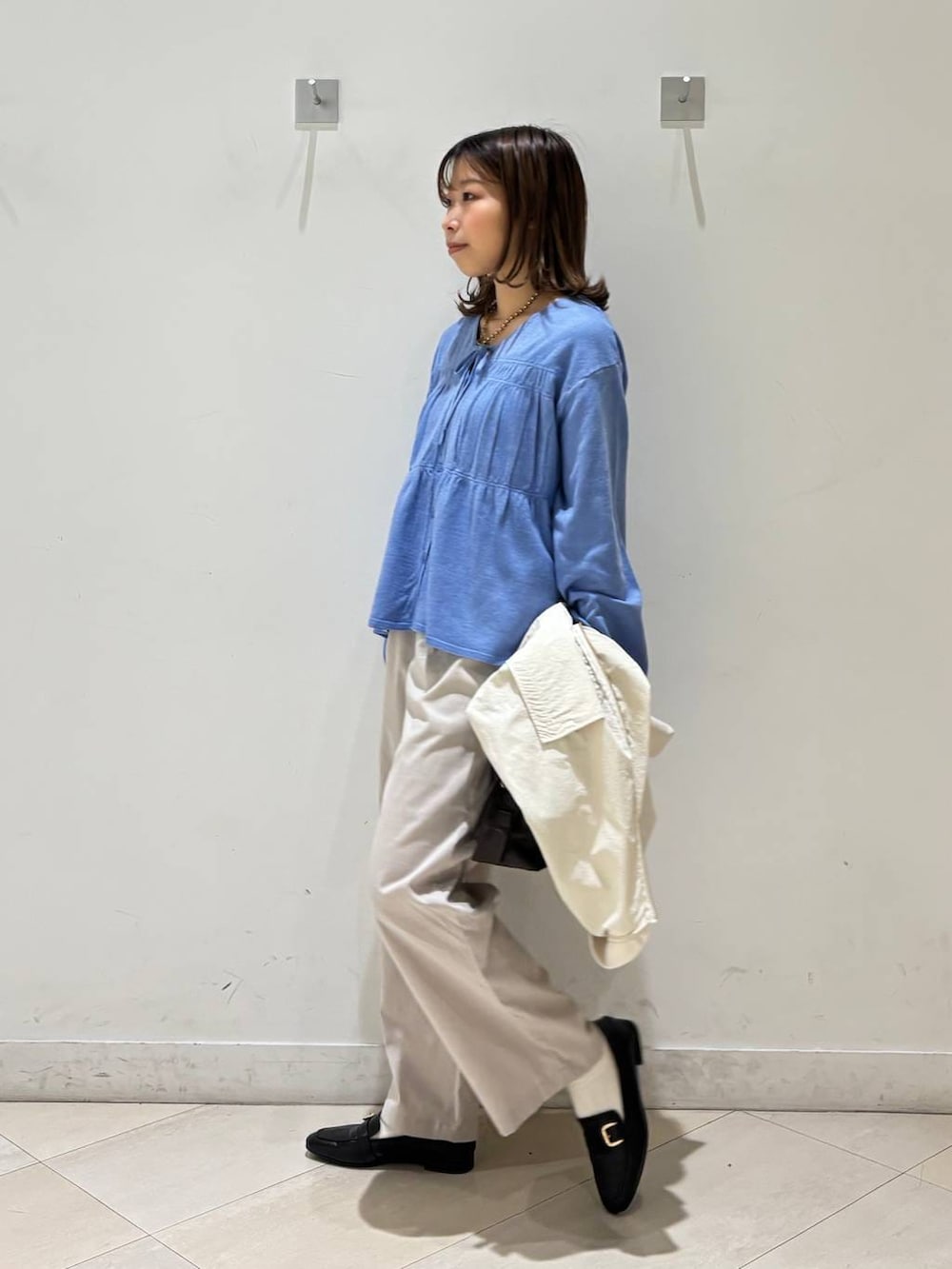 ブラック系のローファー、ホワイト系のその他パンツ、ブラウン系のボストンバッグを着用したレディースの春コーディネートの4枚目の写真