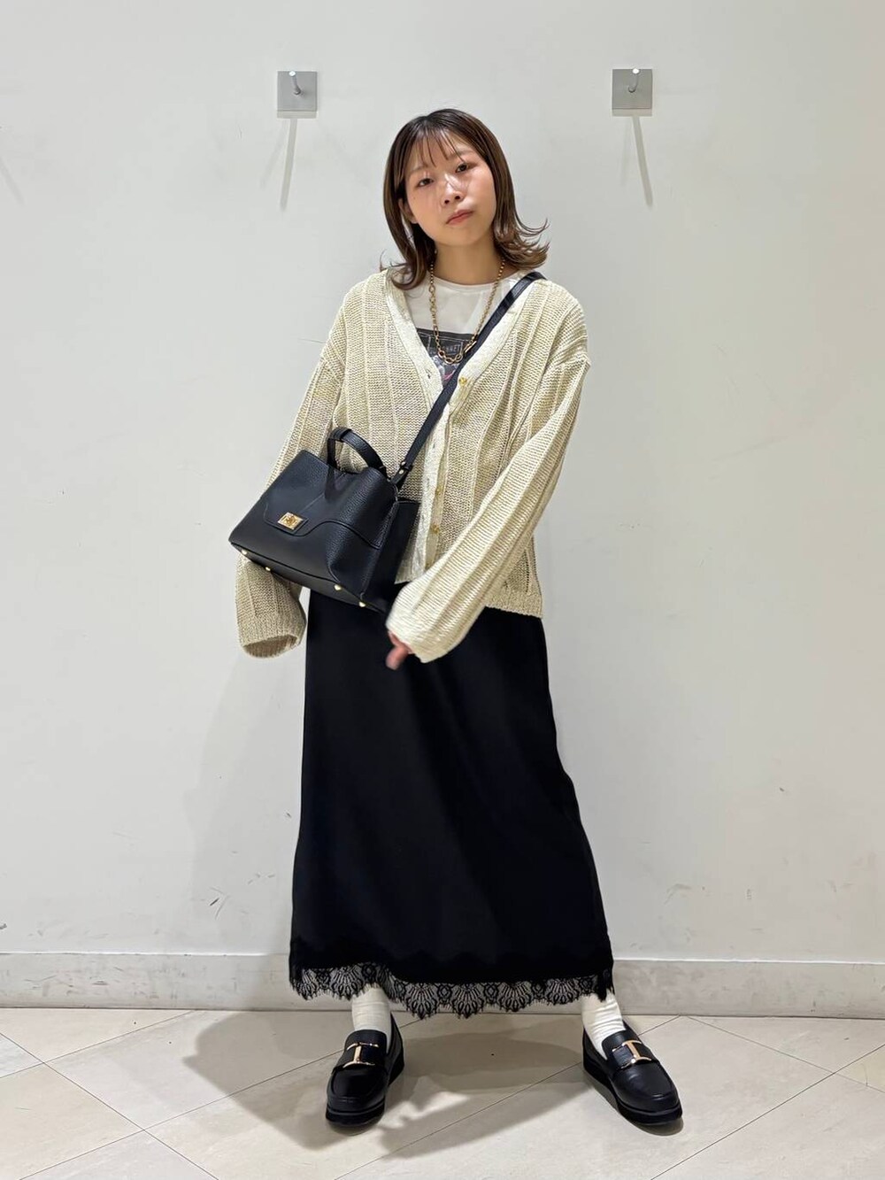 ブラック系のローファー、ホワイト系のTシャツ/カットソー、ホワイト系のカーディガン/ボレロを着用したレディースの春コーディネートの8枚目の写真