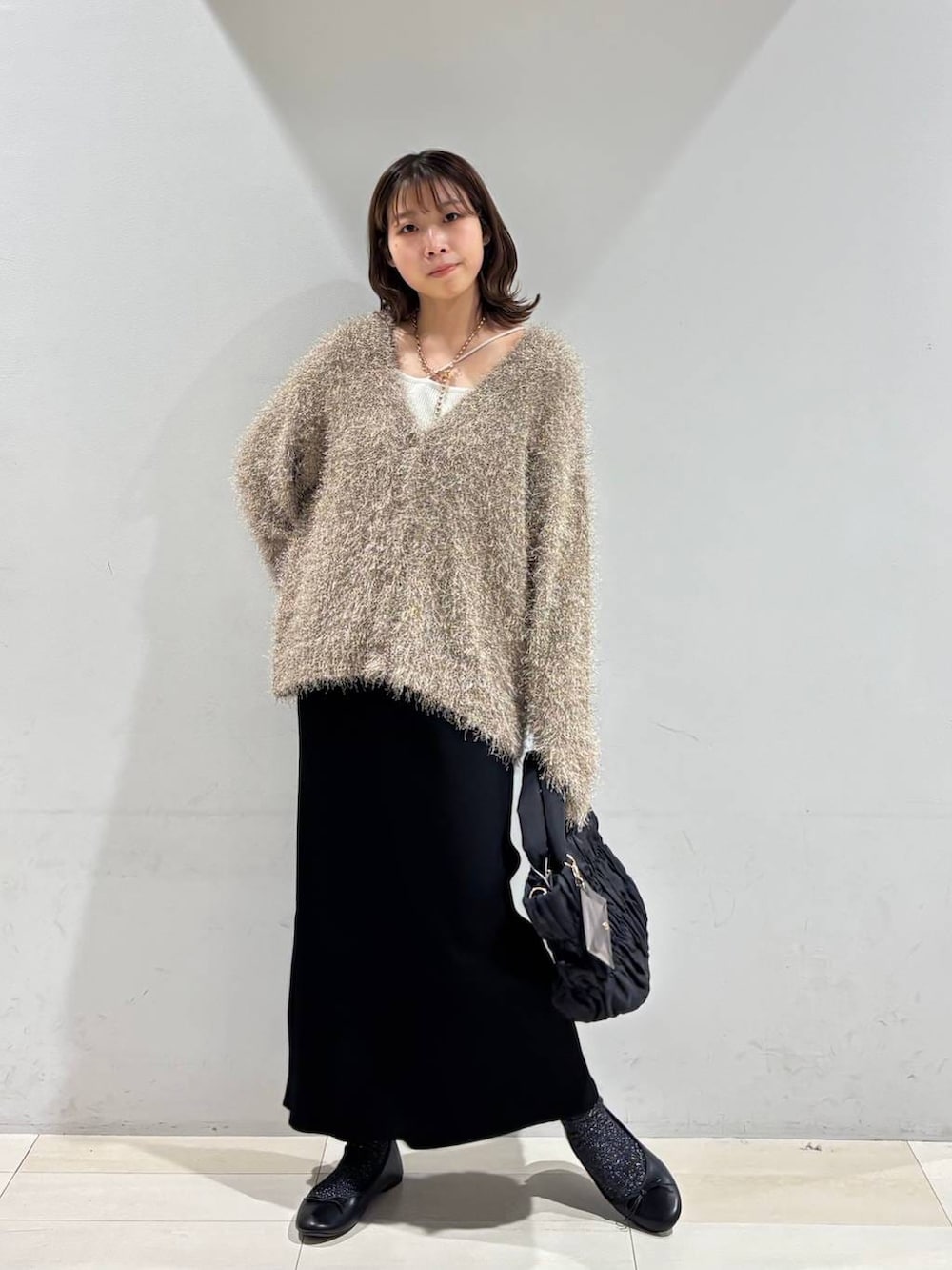 ブラック系のバレエシューズ、ブラック系のトートバッグ、ブラック系のスカートを着用したレディースの春コーディネートの7枚目の写真