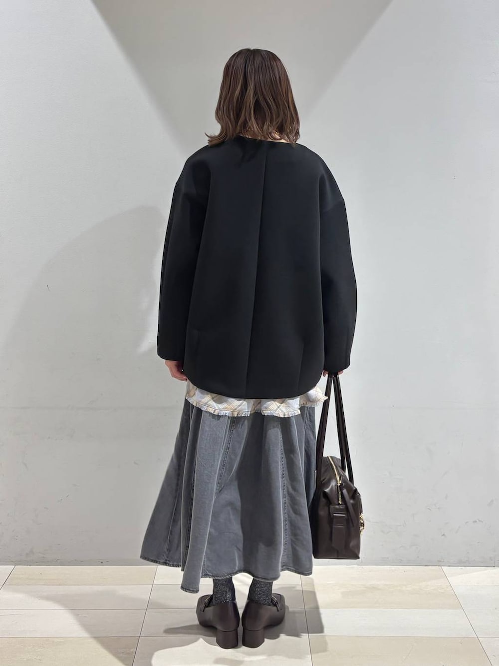 ブラウン系のローファー、ブラウン系のボストンバッグ、ブラック系のブルゾンを着用したレディースの春コーディネートの4枚目の写真