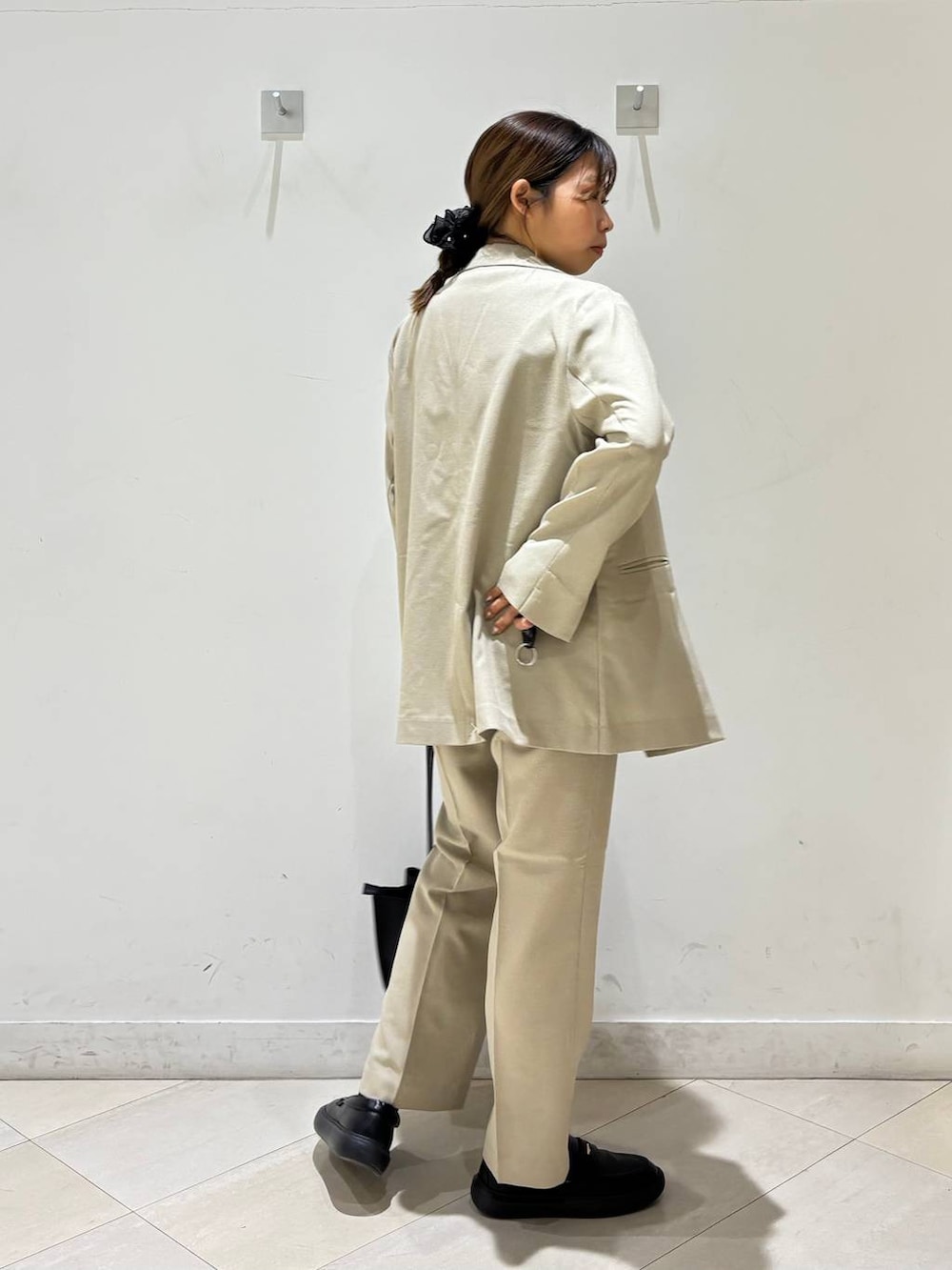 ベージュ系のその他パンツ、ベージュ系のテーラードジャケット、ブラック系のトートバッグを着用したレディースの春コーディネートの6枚目の写真