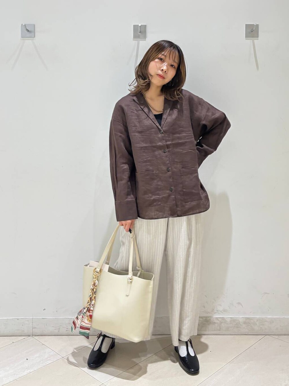 ブラック系のキャミソール、ブラウン系のシャツ/ブラウス、ベージュ系のその他パンツを着用したレディースの春コーディネートの9枚目の写真