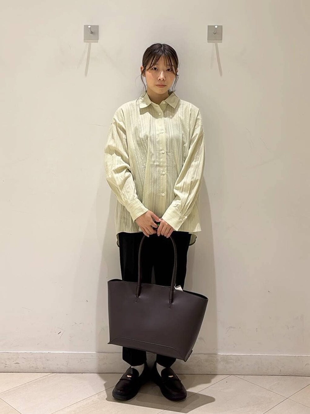 ブラック系のその他パンツ、ブラウン系のトートバッグ、ブラウン系のスニーカーを着用したレディースの春コーディネートの7枚目の写真