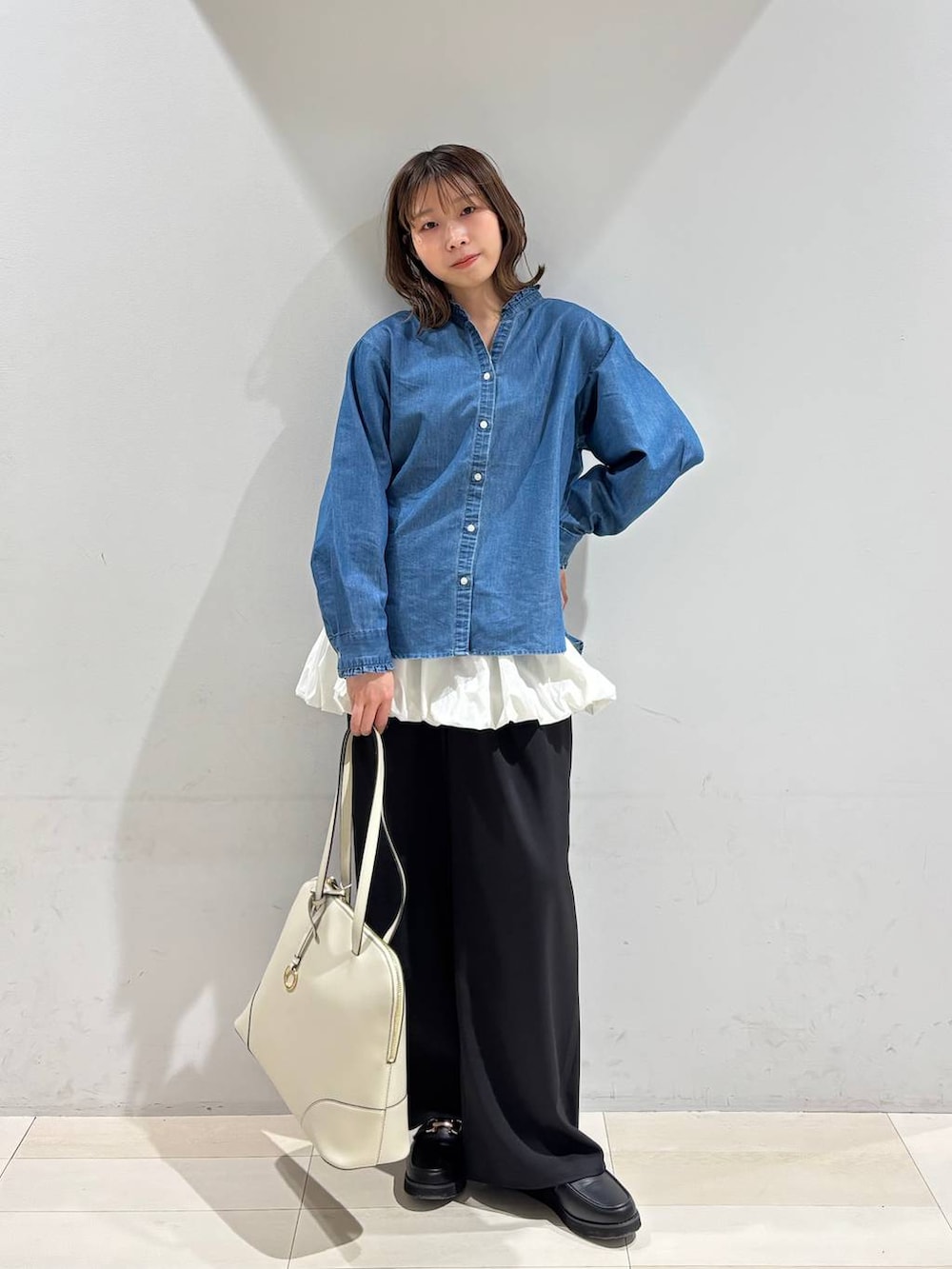 ブラック系のローファー、ベージュ系のボストンバッグ、ブルー系のシャツ/ブラウスを着用したレディースの春コーディネートの2枚目の写真