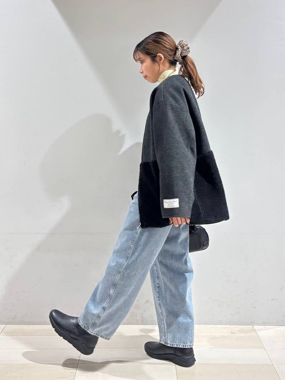 ブルー系のデニムパンツ、ブラック系のブーツ、ブラック系のTシャツ/カットソーを着用したレディースの冬コーディネートの8枚目の写真