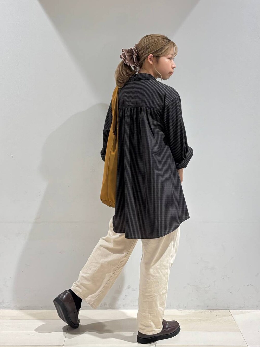 ベージュ系のデニムパンツ、ブラウン系のローファー、イエロー系のトートバッグを着用したレディースの夏コーディネートの6枚目の写真