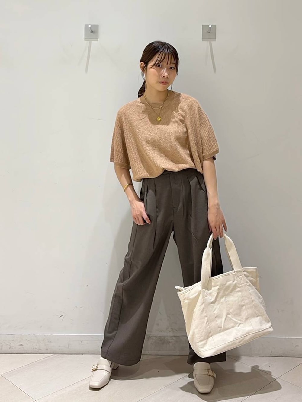 ベージュ系のローファー、ホワイト系のトートバッグ、オレンジ系のニット/セーターを着用したレディースの春コーディネートの2枚目の写真