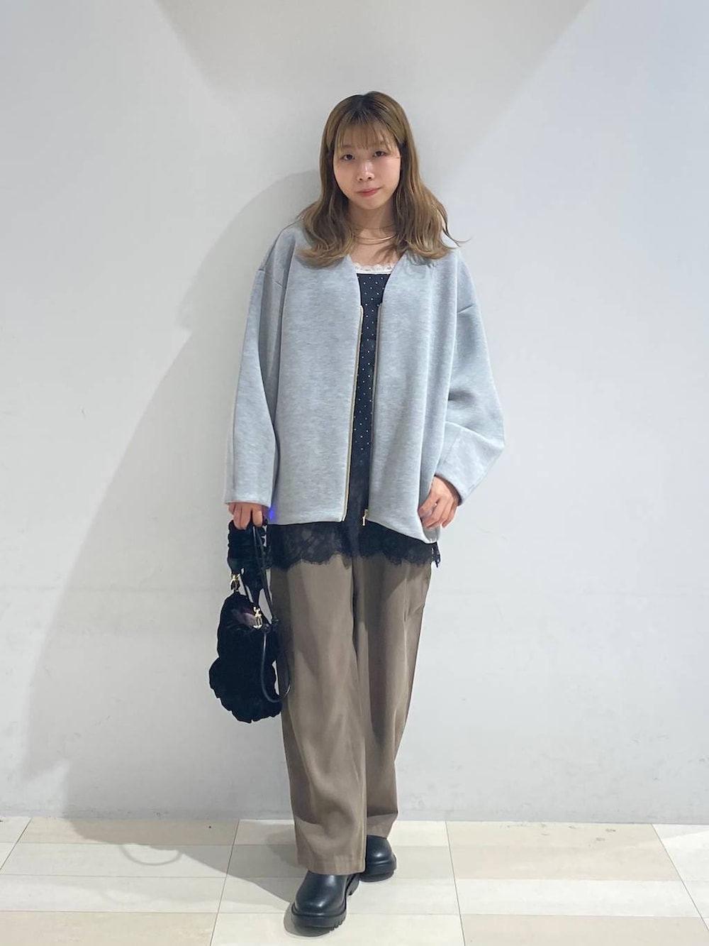 グリーン系のその他パンツ、ブラック系のブーツ、ホワイト系のキャミソールを着用したレディースの秋コーディネートの8枚目の写真