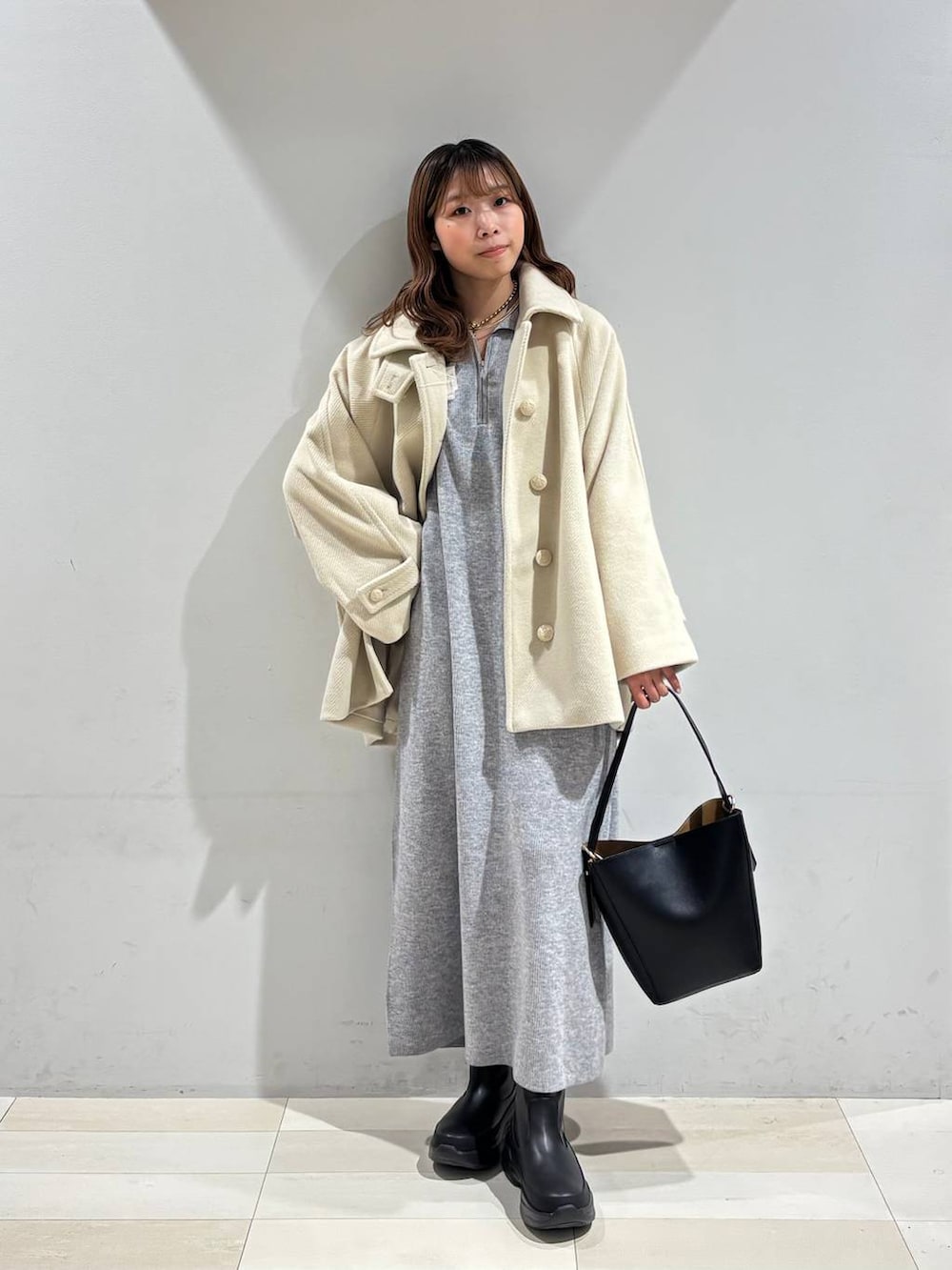 ブラック系のショルダーバッグ、グレー系のワンピース、ブラック系のブーツを着用したレディースの冬コーディネートの9枚目の写真