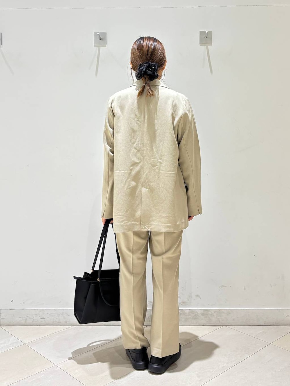 ベージュ系のその他パンツ、ベージュ系のテーラードジャケット、ブラック系のトートバッグを着用したレディースの春コーディネートの4枚目の写真