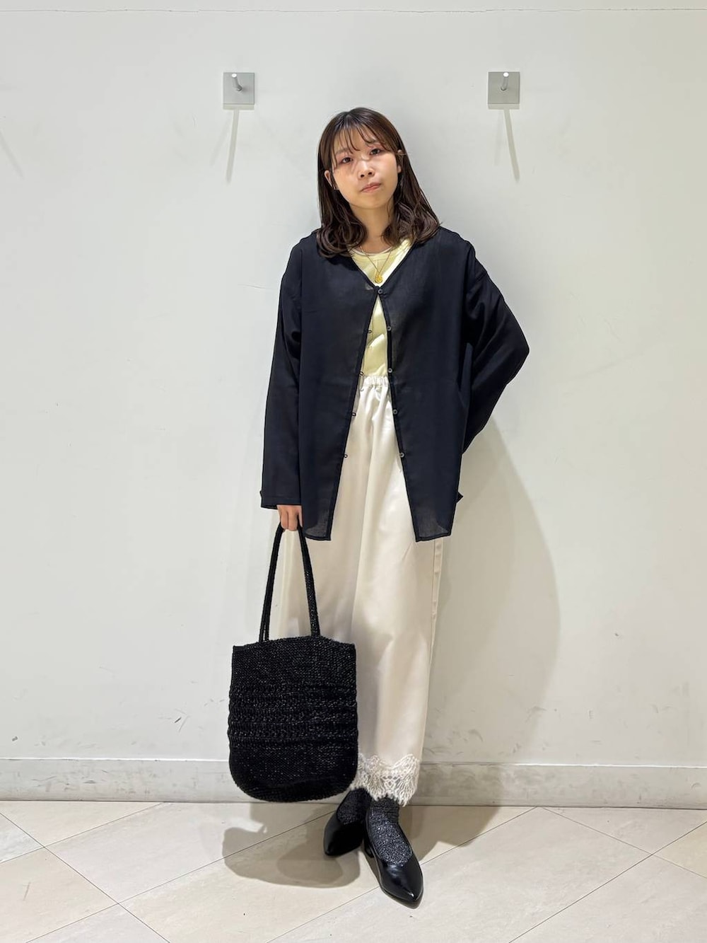 ブラック系のパンプス、ブラック系のクラッチバッグ、ブラック系のカーディガン/ボレロを着用したレディースの夏コーディネートの2枚目の写真