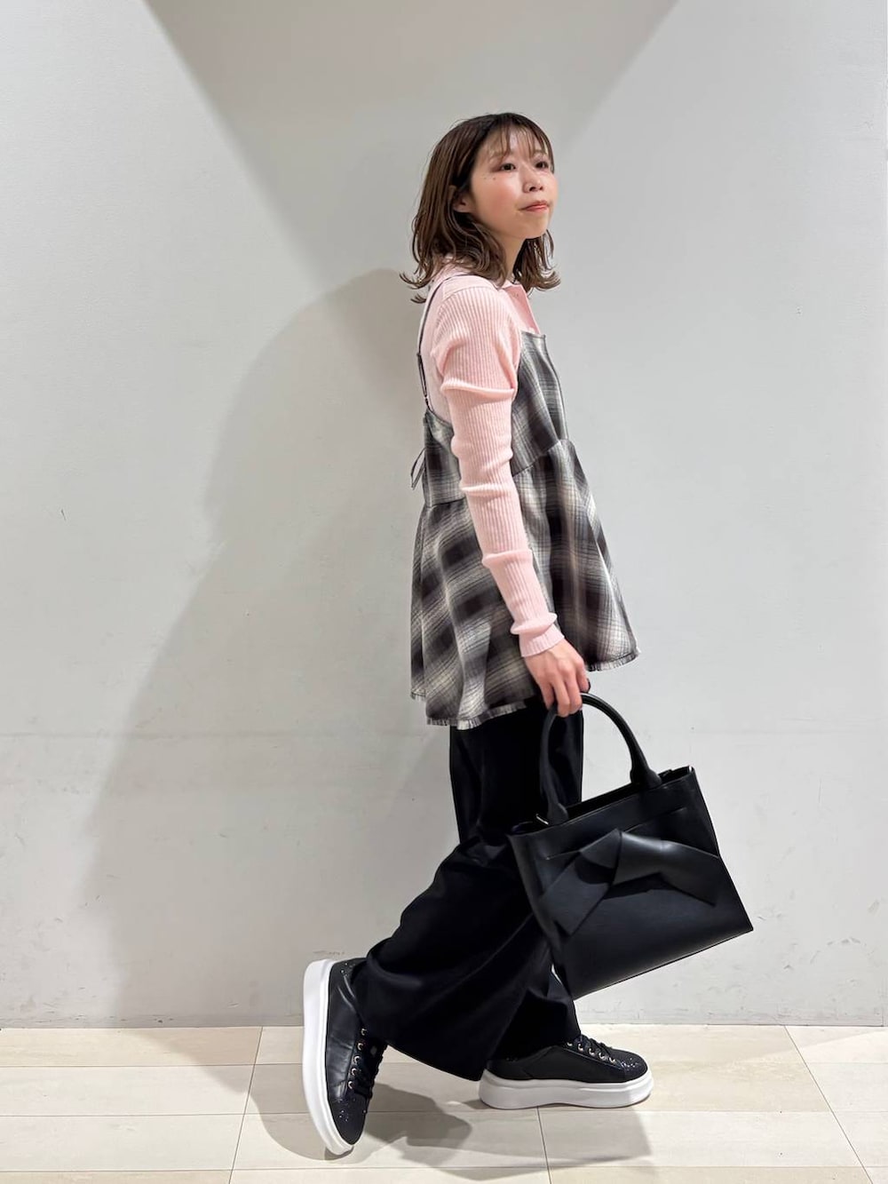 ブラック系のハンドバッグ、ブラック系のその他パンツ、ブラウン系のその他トップスを着用したレディースの春コーディネートの3枚目の写真