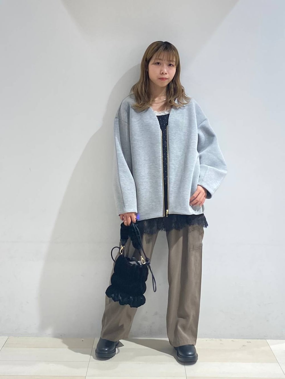 グリーン系のその他パンツ、ブラック系のブーツ、ホワイト系のキャミソールを着用したレディースの秋コーディネートの9枚目の写真