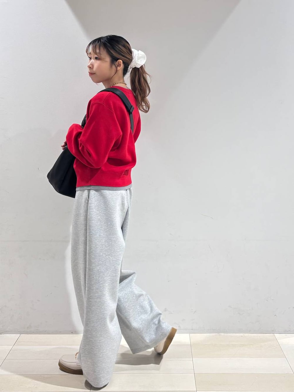 ホワイト系のローファー、ブラック系のショルダーバッグ、グレー系のスウェットパンツを着用したレディースの冬コーディネートの4枚目の写真