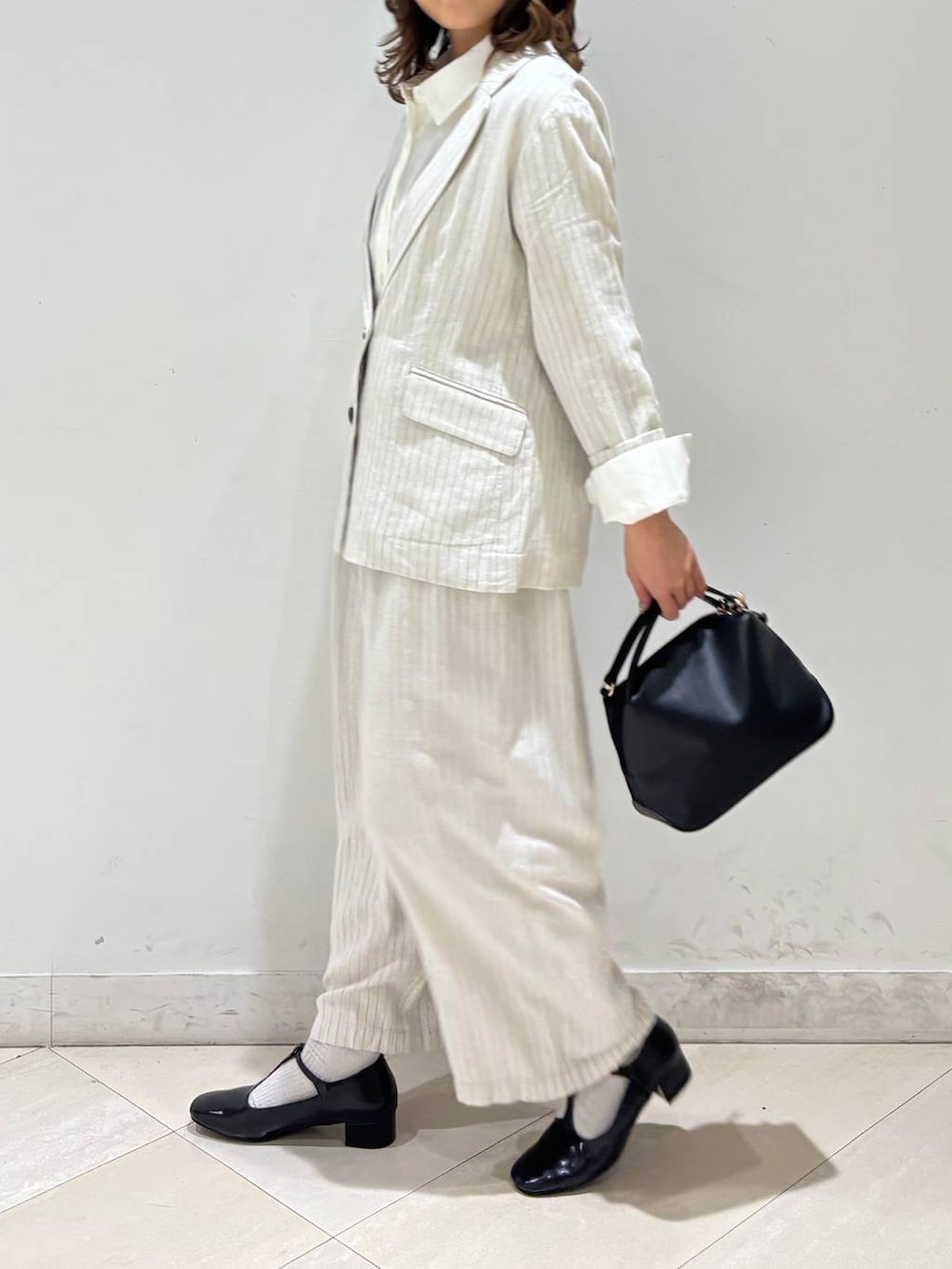 ブラック系のショルダーバッグ、ベージュ系のその他パンツ、グレー系のテーラードジャケットを着用したレディースの春コーディネートの4枚目の写真