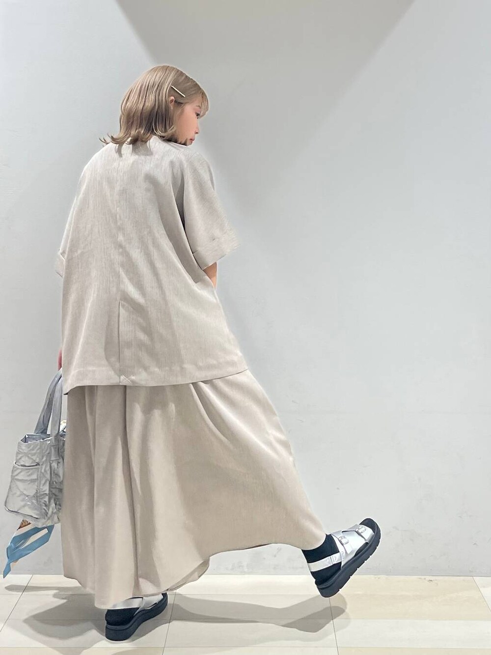 シルバー系のトートバッグ、ホワイト系のキャミソール、シルバー系のサンダルを着用したレディースの夏コーディネートの5枚目の写真