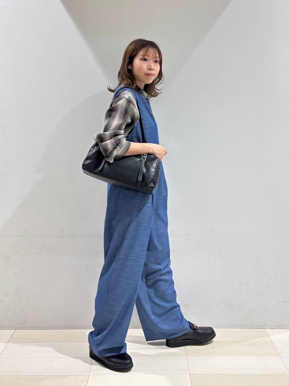 ブラック系のローファー、ブラウン系のシャツ/ブラウス、ブラック系のショルダーバッグを着用したレディースの春コーディネートの2枚目の写真