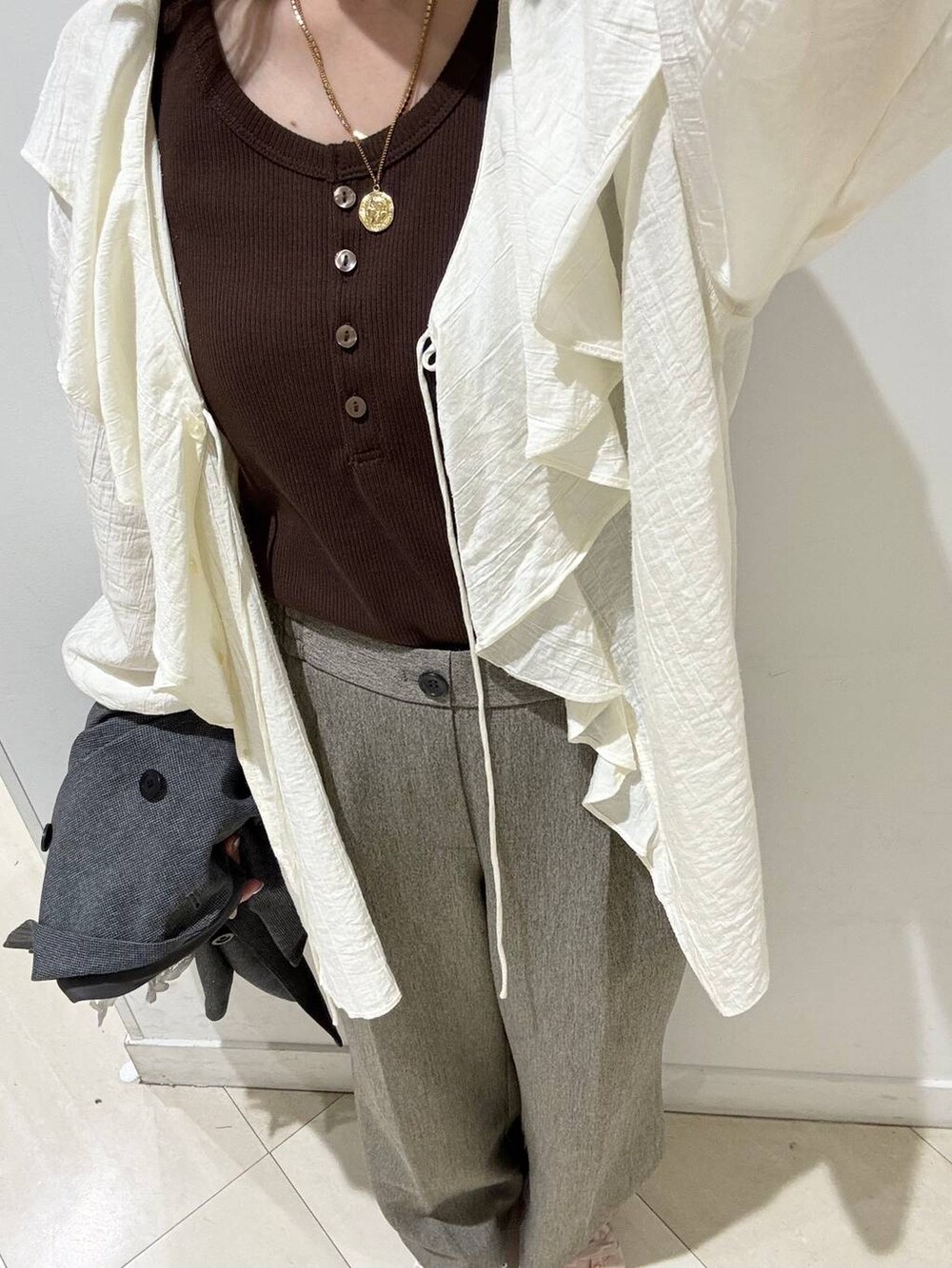 ベージュ系のその他パンツ、グレー系のテーラードジャケット、ブラウン系のタンクトップを着用したレディースの春コーディネートの4枚目の写真