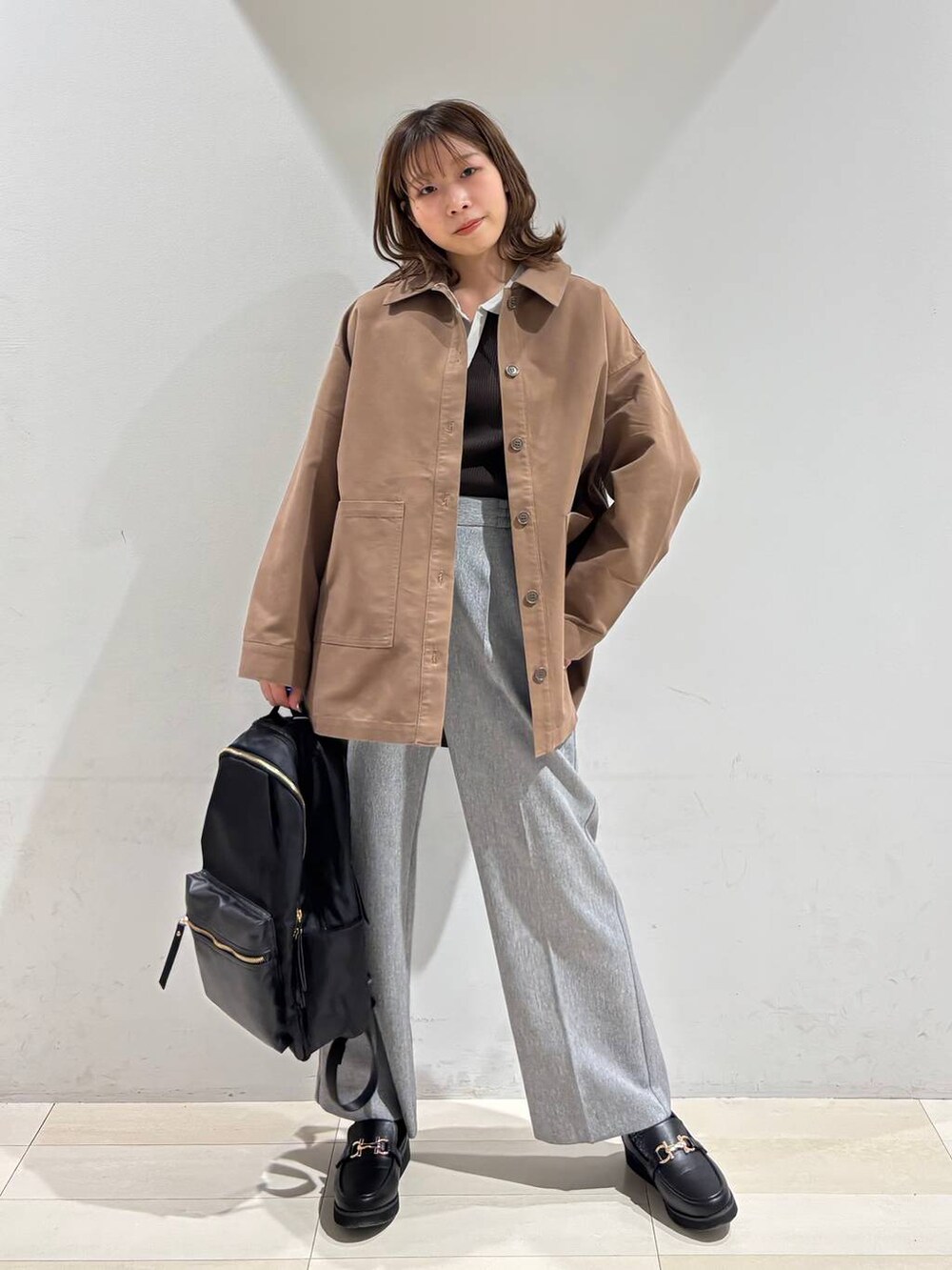 ブラック系のローファー、ブラック系のバックパック/リュック、グレー系のその他パンツを着用したレディースの春コーディネートの8枚目の写真