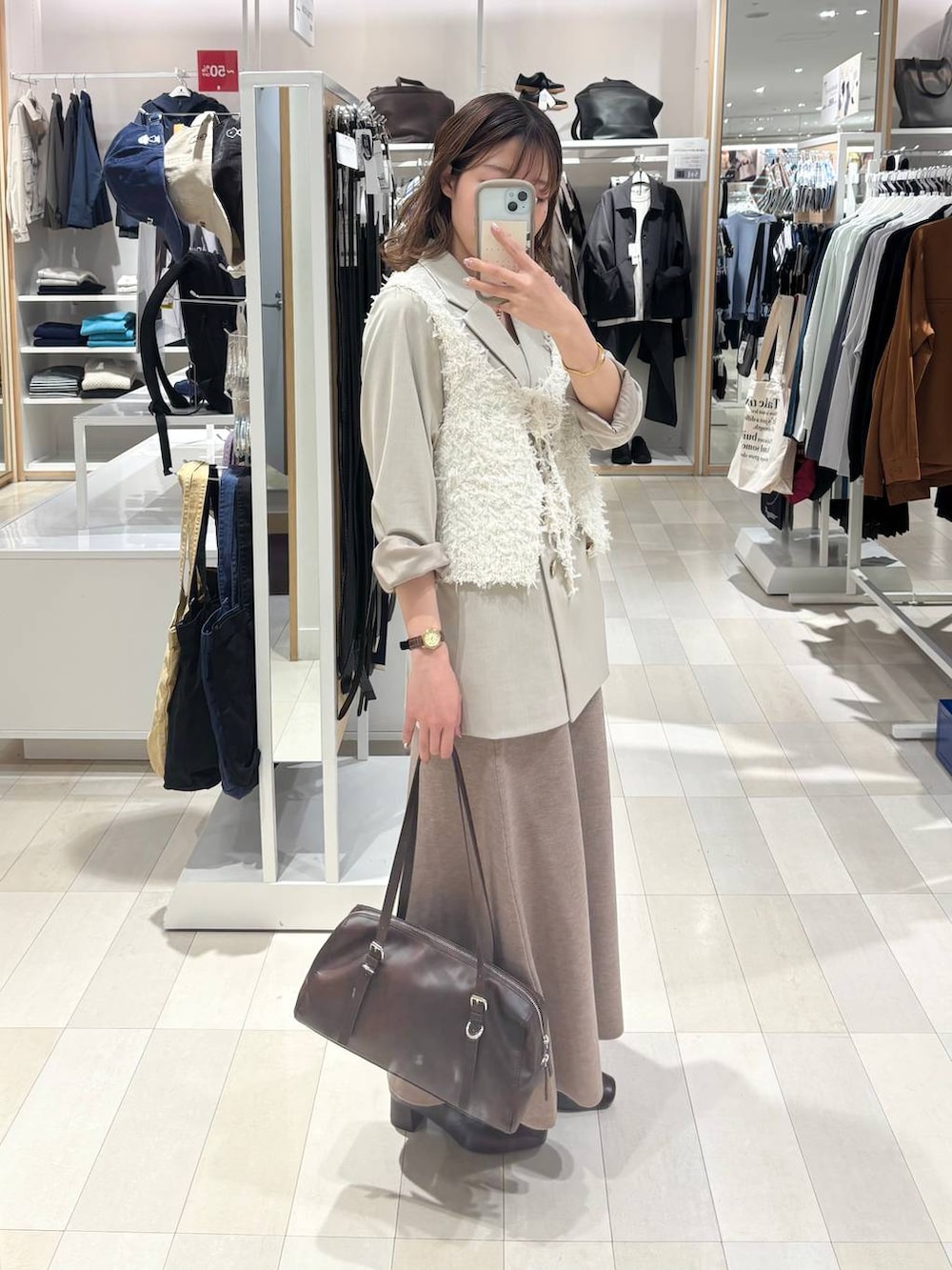 ブラウン系のローファー、ホワイト系のキャミソール、ベージュ系のテーラードジャケットを着用したレディースの春コーディネートの2枚目の写真