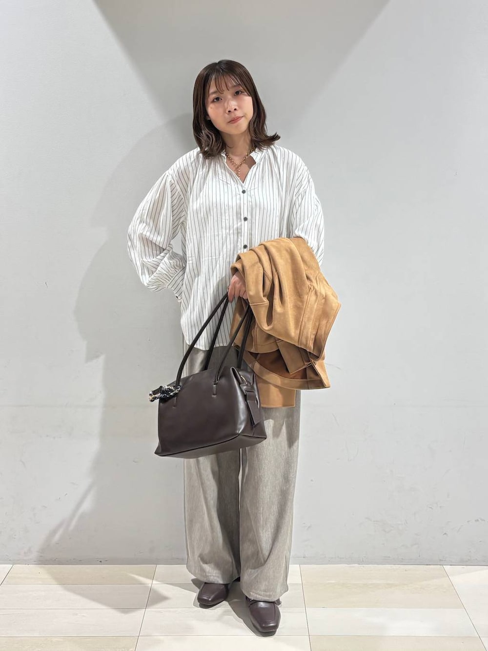 ブラウン系のローファー、ブラウン系のボストンバッグ、ブラウン系のテーラードジャケットを着用したレディースの春コーディネートの2枚目の写真