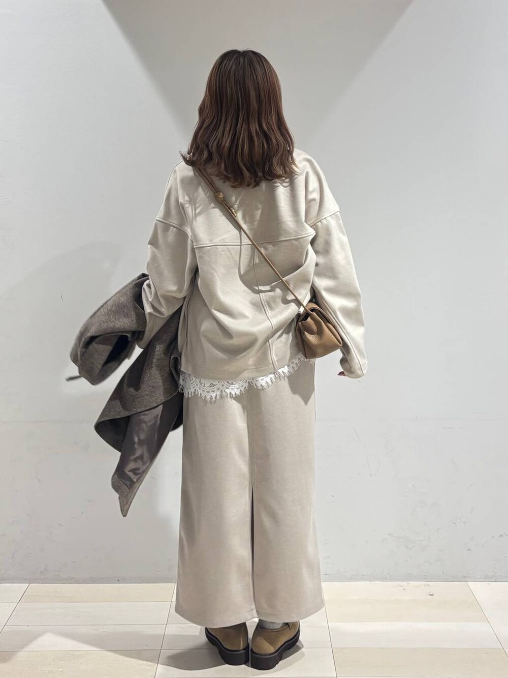 ブラウン系のチェスターコート、ベージュ系のローファー、ベージュ系のショルダーバッグを着用したレディースの秋コーディネートの8枚目の写真