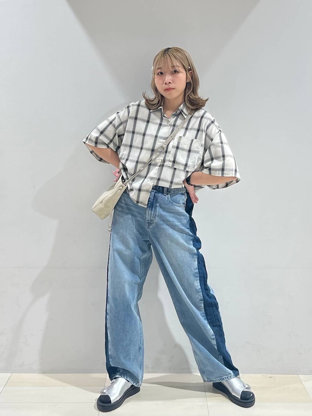 シルバー系のサンダル、ベージュ系のショルダーバッグ、ブルー系のデニムパンツを着用したレディースの夏コーディネートの6枚目の写真