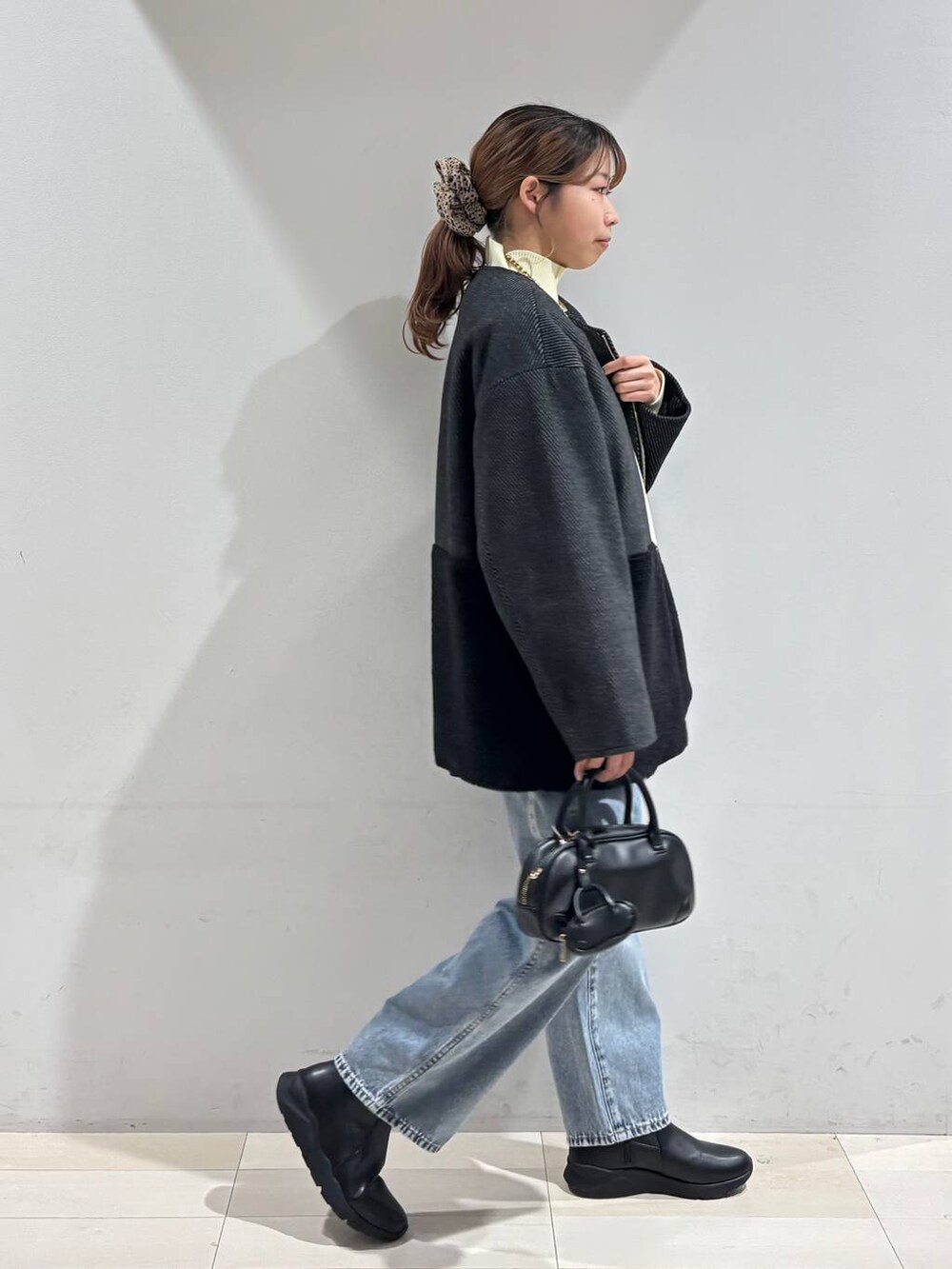 ブルー系のデニムパンツ、ブラック系のブーツ、ブラック系のTシャツ/カットソーを着用したレディースの冬コーディネートの6枚目の写真