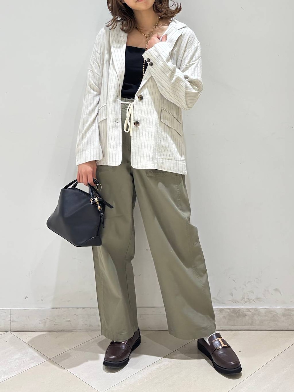 ブラック系のショルダーバッグ、ブラウン系のローファー、ブラック系のキャミソールを着用したレディースの春コーディネートの9枚目の写真