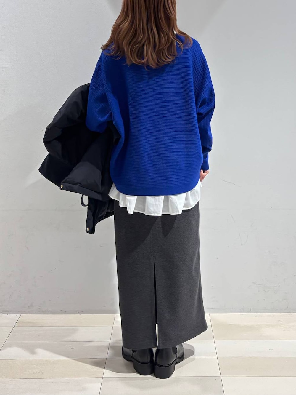 ブラック系のショルダーバッグ、ブラック系のダウンジャケット/コート、ホワイト系のTシャツ/カットソーを着用したレディースの冬コーディネートの3枚目の写真