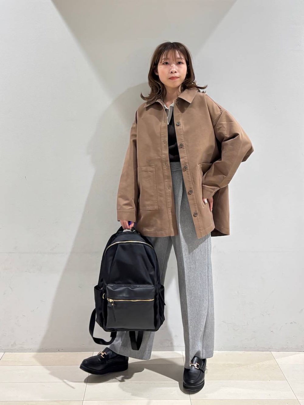 ブラック系のローファー、ブラック系のバックパック/リュック、グレー系のその他パンツを着用したレディースの春コーディネートの3枚目の写真