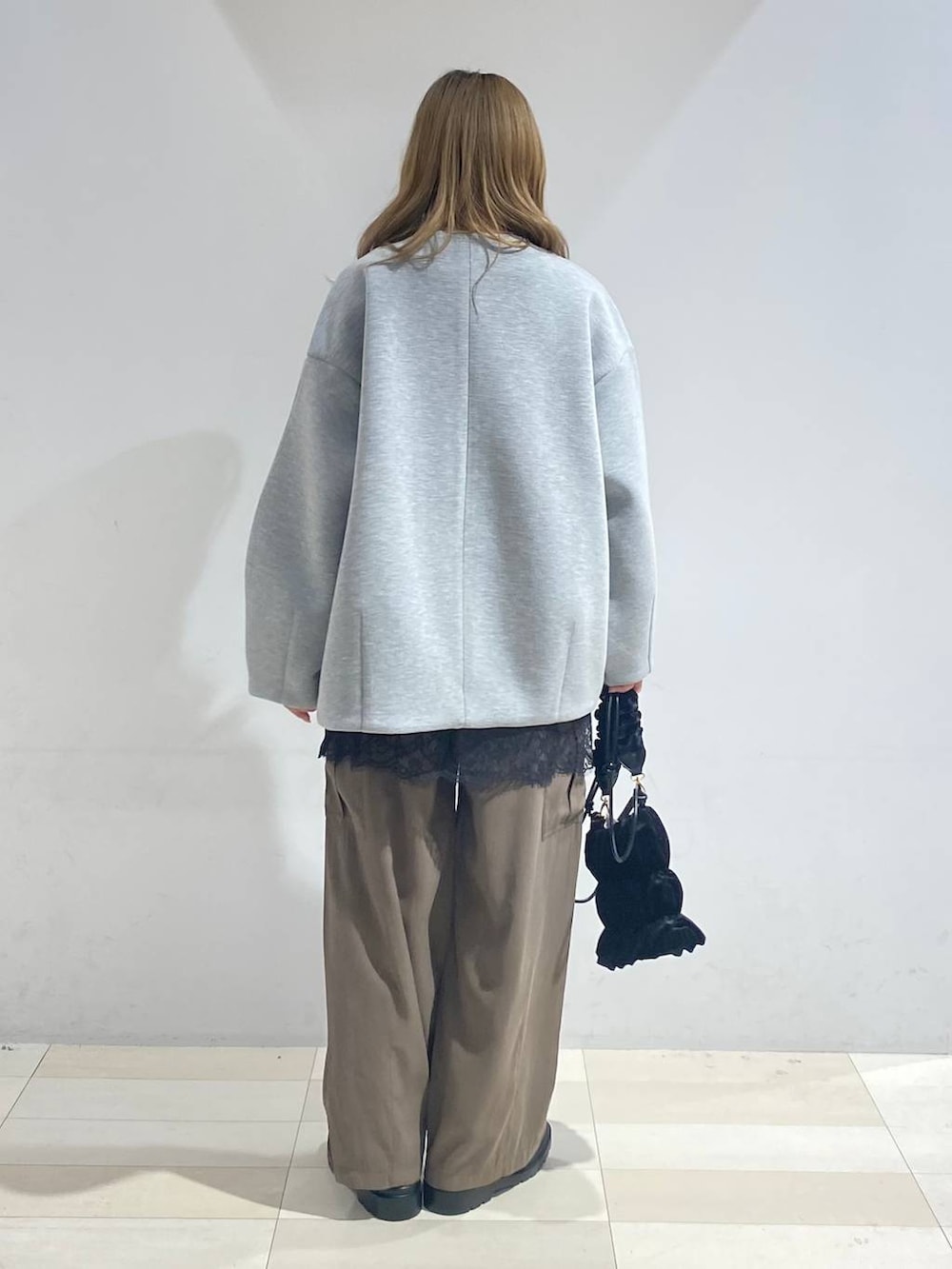 グリーン系のその他パンツ、ブラック系のブーツ、ホワイト系のキャミソールを着用したレディースの秋コーディネートの5枚目の写真