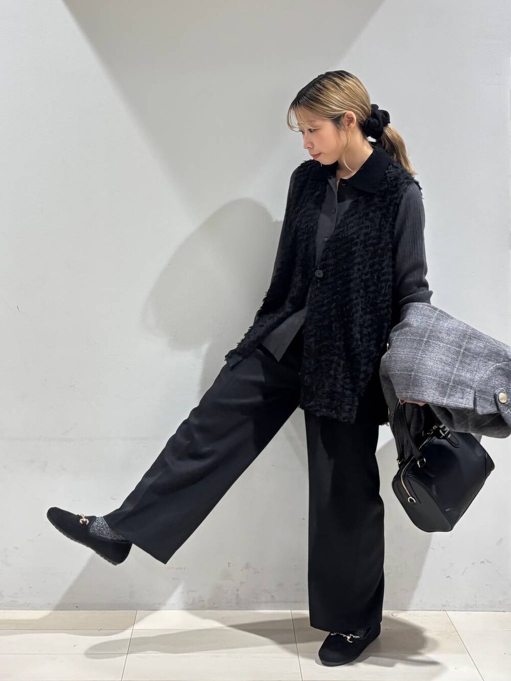 その他のチェスターコート、ブラック系のベスト、ブラック系のその他パンツを着用したレディースの秋コーディネートの3枚目の写真