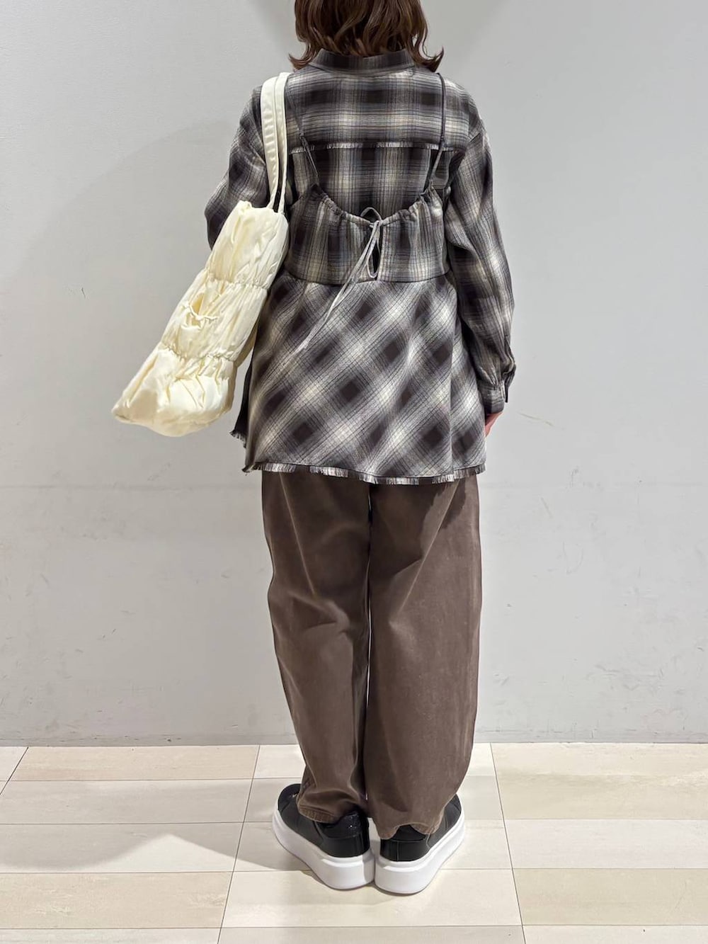 ベージュ系のトートバッグ、ブラウン系のデニムパンツ、ブラウン系のシャツ/ブラウスを着用したレディースの春コーディネートの5枚目の写真