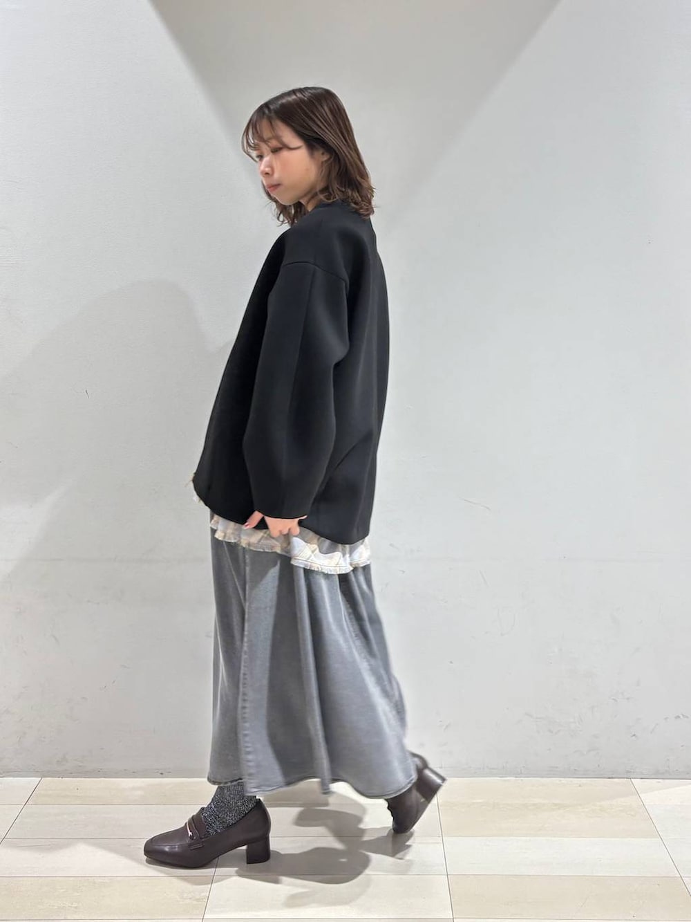 ブラウン系のローファー、ブラウン系のボストンバッグ、ブラック系のブルゾンを着用したレディースの春コーディネートの6枚目の写真