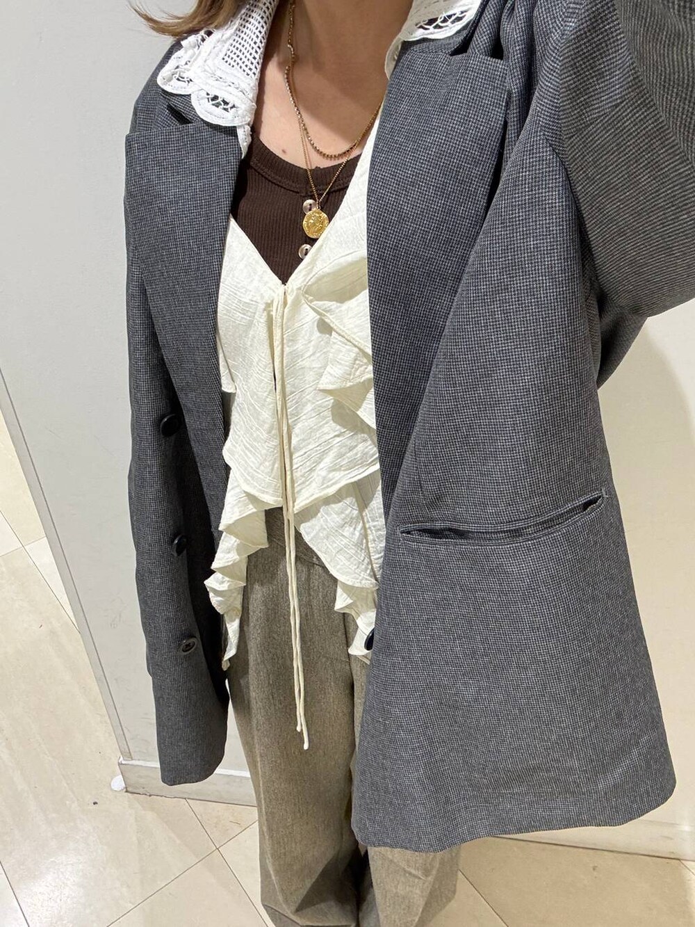 ベージュ系のその他パンツ、グレー系のテーラードジャケット、ブラウン系のタンクトップを着用したレディースの春コーディネートの10枚目の写真