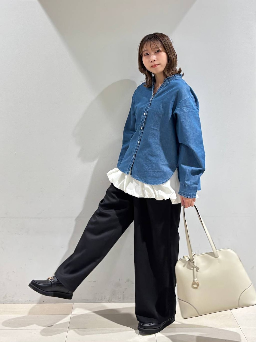 ブラック系のローファー、ベージュ系のボストンバッグ、ブルー系のシャツ/ブラウスを着用したレディースの春コーディネートの3枚目の写真