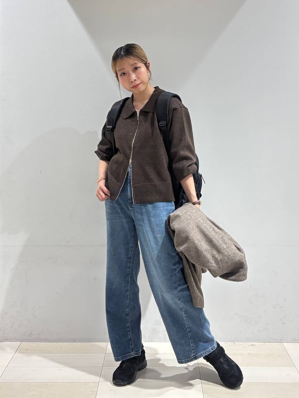 ブラック系のバックパック/リュック、ブラウン系のチェスターコート、ブラウン系のワンピースを着用したレディースの秋コーディネートの7枚目の写真