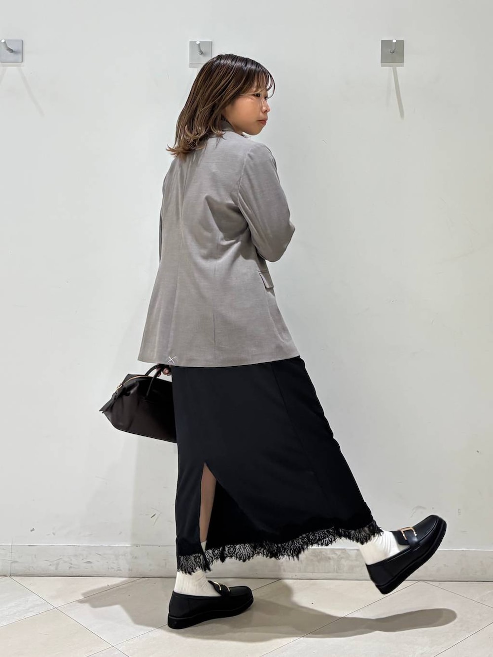 ブラック系のローファー、ブラウン系のテーラードジャケット、ブラウン系のボストンバッグを着用したレディースの春コーディネートの5枚目の写真