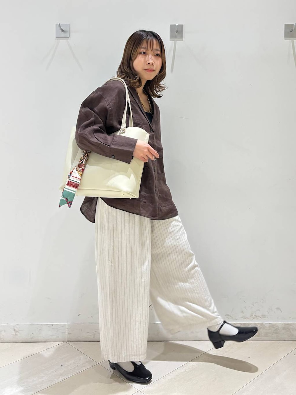 ブラック系のキャミソール、ブラウン系のシャツ/ブラウス、ベージュ系のその他パンツを着用したレディースの春コーディネートの2枚目の写真