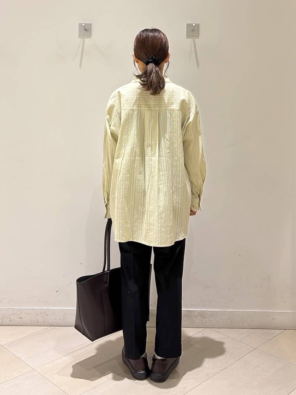 ブラック系のその他パンツ、ブラウン系のトートバッグ、ブラウン系のスニーカーを着用したレディースの春コーディネートの4枚目の写真