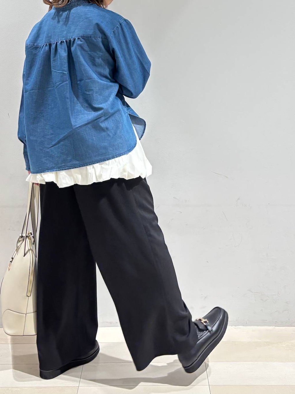 ブラック系のローファー、ベージュ系のボストンバッグ、ブルー系のシャツ/ブラウスを着用したレディースの春コーディネートの6枚目の写真