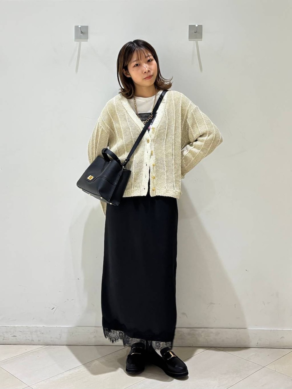 ブラック系のローファー、ホワイト系のTシャツ/カットソー、ホワイト系のカーディガン/ボレロを着用したレディースの春コーディネートの2枚目の写真