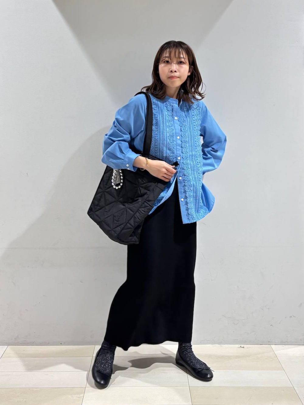 ブラック系のバレエシューズ、ブラック系のトートバッグ、ブラック系のスカートを着用したレディースの冬コーディネートの2枚目の写真